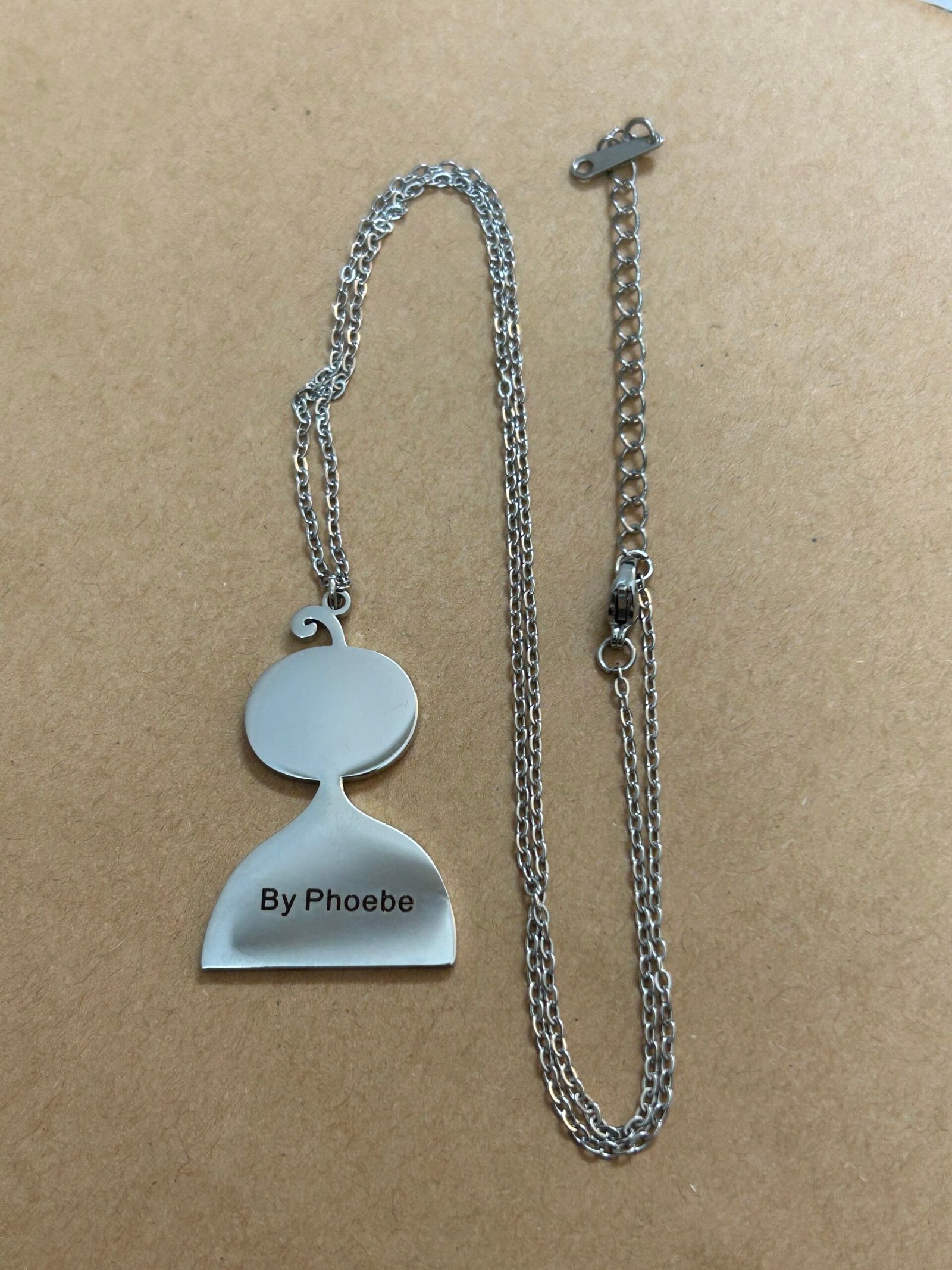 A personalised Doobee pendant and chain, engraved with a name on the back